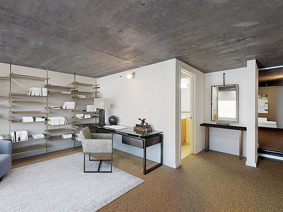 Carpeted loft office with bedroom and bathroom.