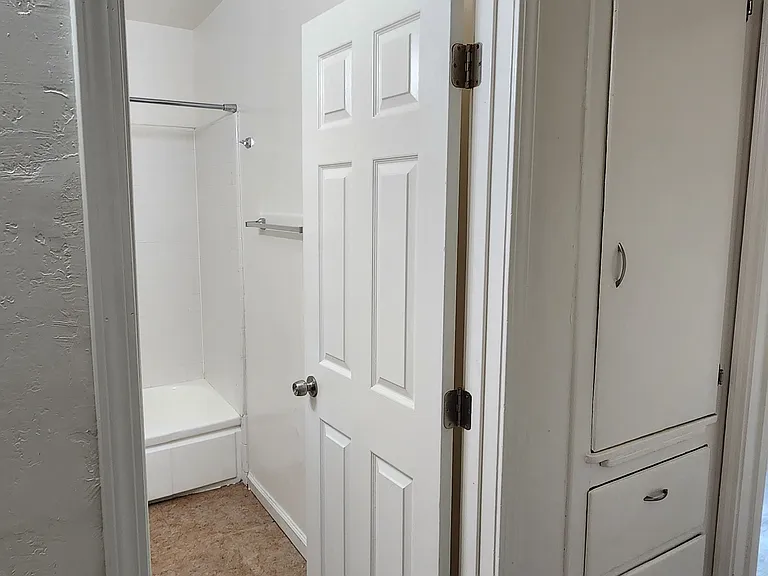 Hallway with storage and door to bathroom