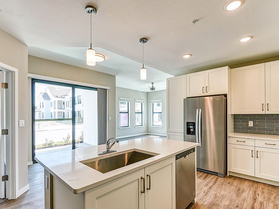 Imperial Crossing Luxury Apartment Homes unit showing a modern kitchen with stainless steel appliances and white cabinets.