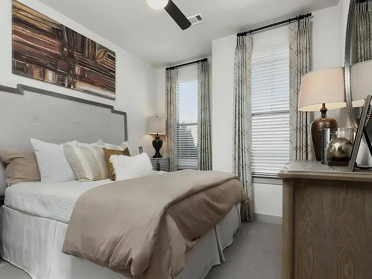 Bedroom with Bed, Dressers, Lamps, and Wall Art Above Headboard