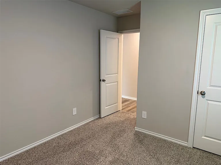 Carpeted room with light neutral walls