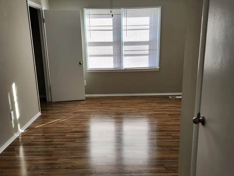 Once upstairs, view of Master Bedroom (#1); lots of natural light, white ceiling fan and two closets on opposite sides of the room; new venetian blinds.