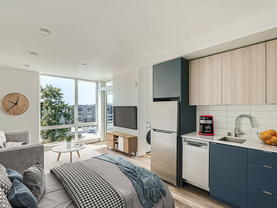 Enjoy the comfort and style of this spacious bedroom at Anker Ballard, complete with a cozy bed, functional desk, and large windows that fill the room with natural light.