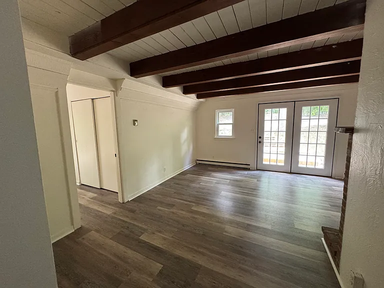 living room looking towards the front entrance doors. Door to the left is to the primary bedroom.
