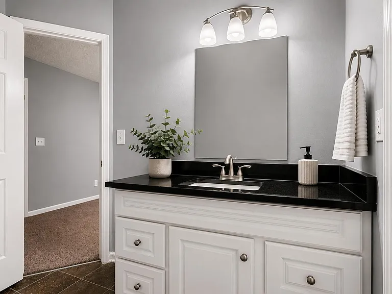 Primary bathroom vanity with ample counter space, large mirror, and storage drawers.