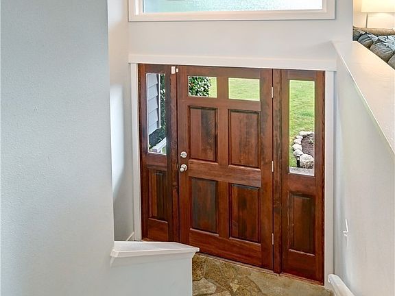 Hardwood stairs, a light infused entry and graceful chandelier.