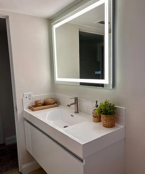 Modern floating vanity and lighted LED mirror in bathroom