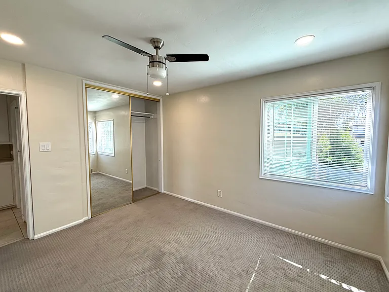 Bedroom with large closet, lots of natural light from west and north facing dual paned windows. The hallway with linen cabinet and utility/storage cabinet.