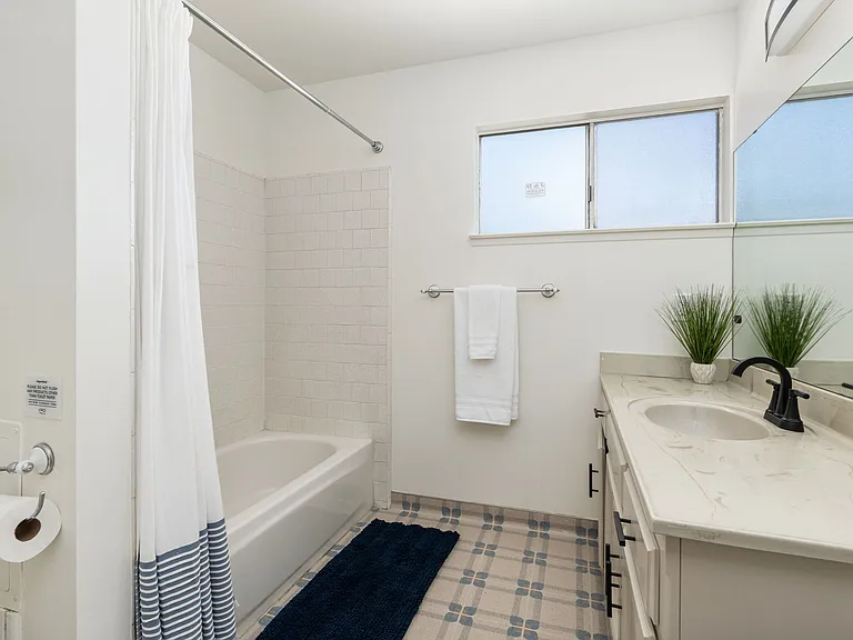 Shared bath with vanity, shower/tub combination.