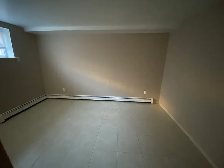 Comfortable bedroom on the second floor featuring durable tile flooring and a spacious closet with sliding doors. A versatile space that can easily accommodate a variety of furniture layouts.