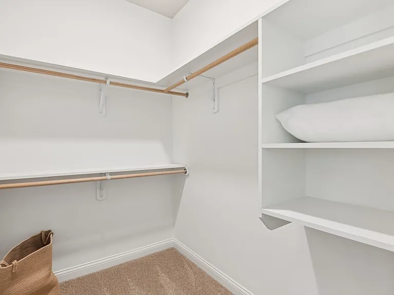 Elevate your daily routine with this elegantly designed walk-in closet, offering ample shelving and a sophisticated layout for effortless organization.