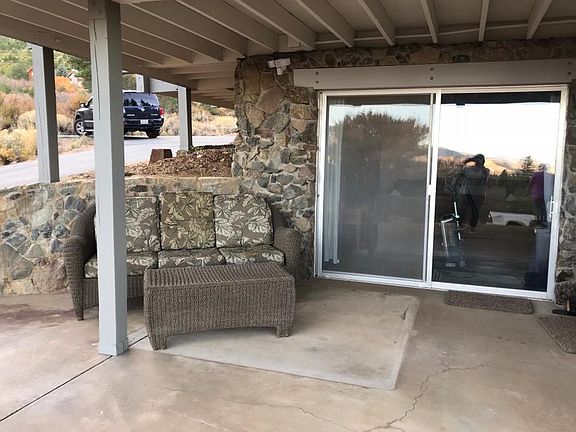 Slider opens to living area/room with stone fireplace.
