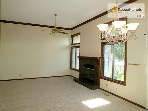 One view of the great room with high ceiling, ceiling fan and fireplace...Anderson Renewal Windows..and...brand new carpet!