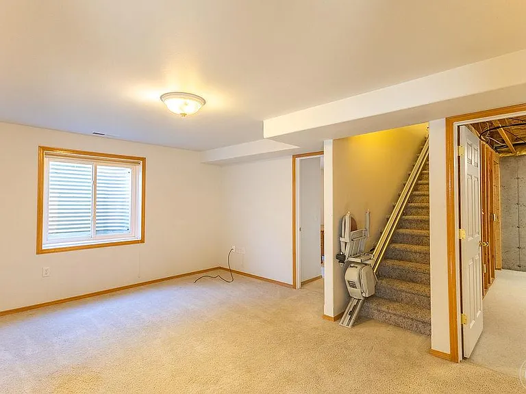 Chairlift is being removed. Downstairs family room with egress window, door to 3rd bedroom on the left and storage on the right