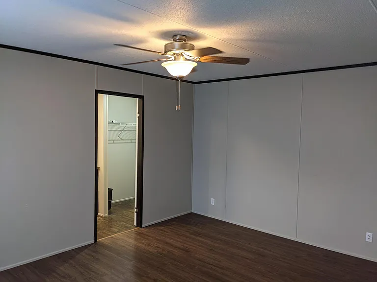 Primary bedroom with large window and ceiling fan