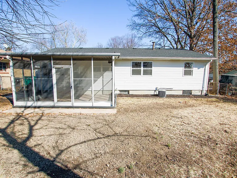Screened in back patio overlooks fenced in backyard