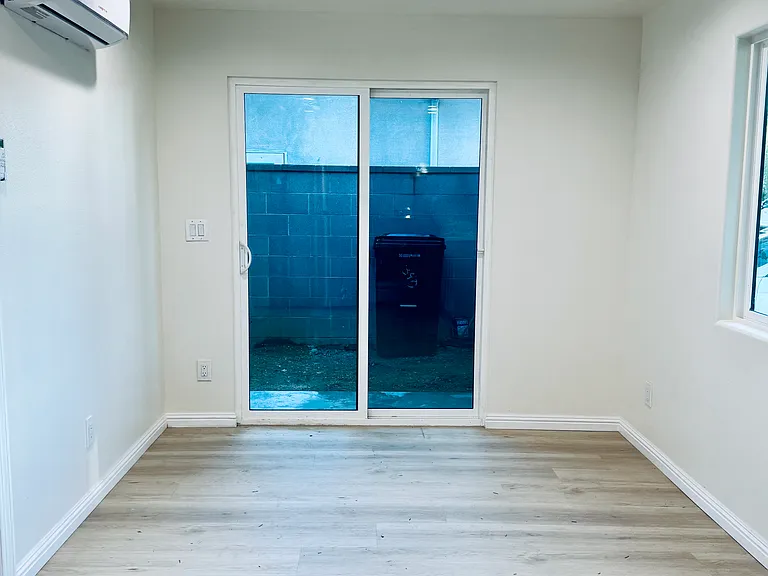 Cozy open concept living space with sliding door opening up to a wrap around garden/private terrance.