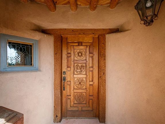 Hand carved front entry with numerous hand made lead glass windows throughout the home