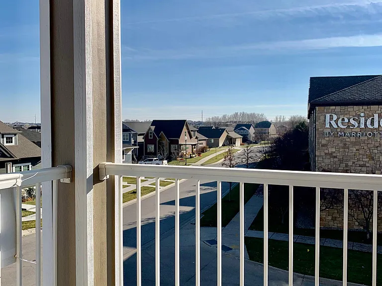 Enjoys fresh air on the covered deck and beautiful views of the neighborhood to the east and south.