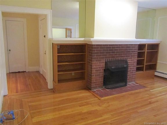 Entry way with coat closet leads into living room with cozy fireplace.