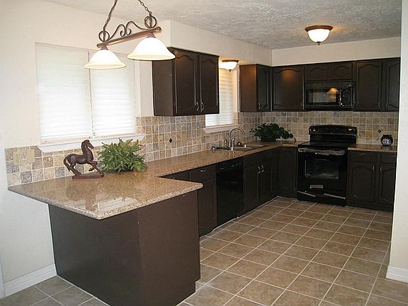 Kitchen has newly added granite counters, tile backsplash/floor and appliances