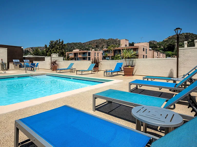 Apartments in Hollywood, CA - Pool, Patio iwth Lounge Chairs and Tables with view of Grilling Area summit