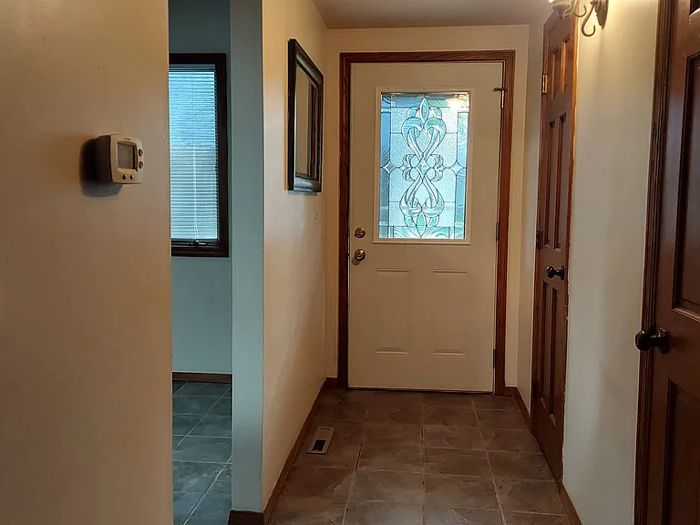 Foyer, Half Bathroom & Coat Closet to the right. Kitchen is on the left with window looking over the Patio.