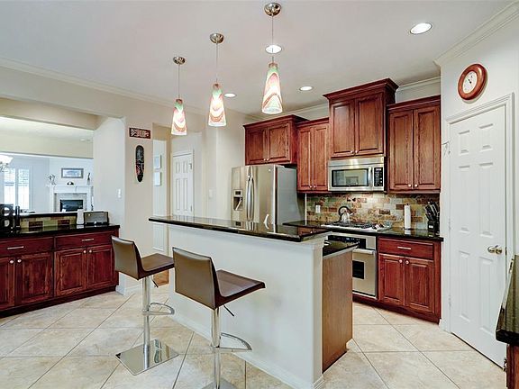 Custom cabinetry adorns this chefs kitchen that overlooks the breakfast and living room. Ample amount of counter space and corner pantry compliments the amount of storage it has to offer.