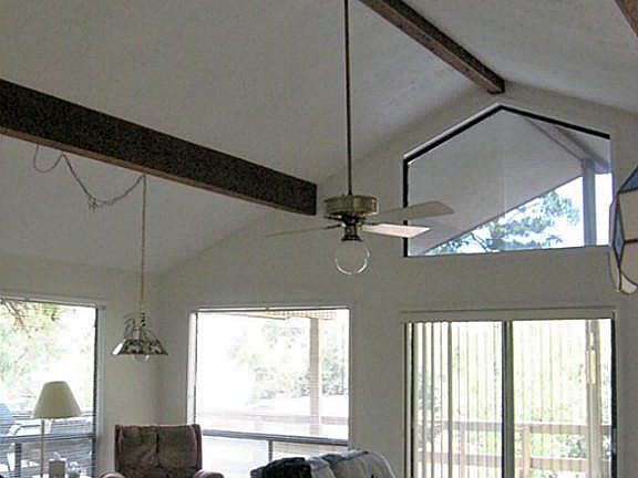 View of living room from dining area. Windows let in lots of light and the lake view