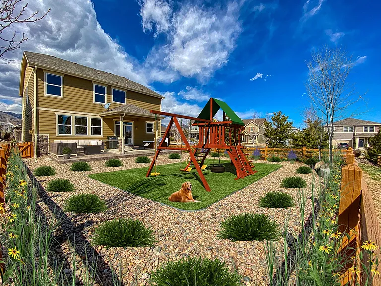 Virtually staged - No-maintenance fenced-in backyard with realistic artificial grass, river rock, covered patio, natural gas line for grill, and views of North Table Mountain.