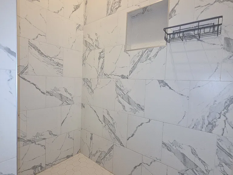 Master/Primary shower surrounded in marble tile