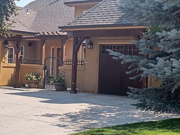 Front of the house with enclosed courtyard with seating. 3 car garage.