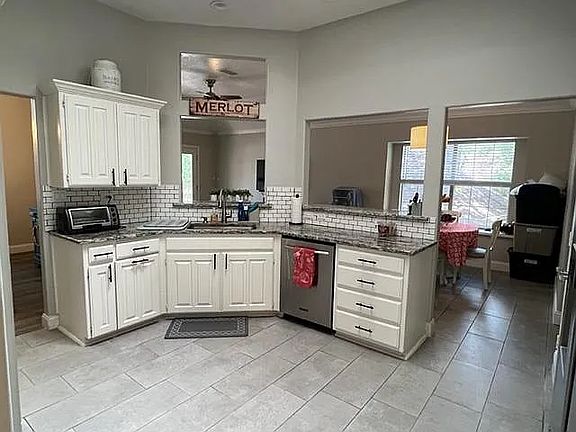Featuring the pass through windows that has countertop seating around and entry to the bonus den/dining area.