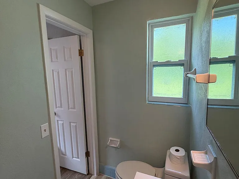 Well-kept bathroom with a pedestal-style sink, mirrored cabinet, and a frosted window for natural light and privacy.