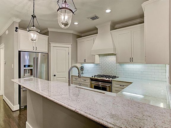 Contemporary kitchen is recently updated (2018) with granite counters, backsplash of classic subway tile, stainless appliances and a large pantry with custom shelving.