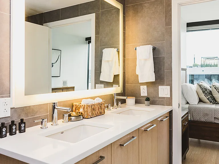 Spa-like bathroom featuring dual vanity and LED back lit mirror