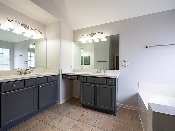 Master bath with two sinks, separate shower and tub