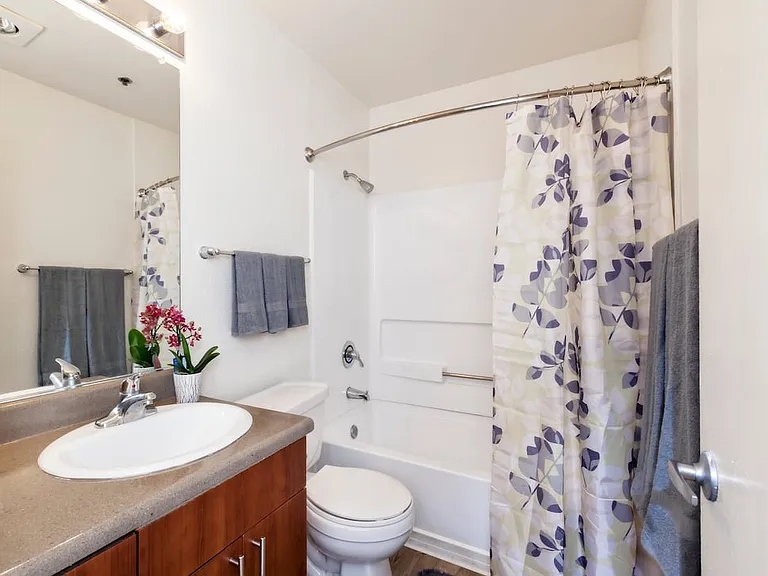 Classic Package bath with dark grey laminate countertop, cherry cabinetry, and hard surface flooring