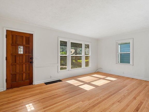 Large front room with lots of natural light and newly refinished original hardwoods
