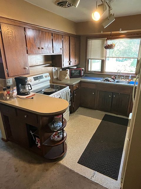 Wrap around kitchen with overhead lighting. Generous cabinet space.