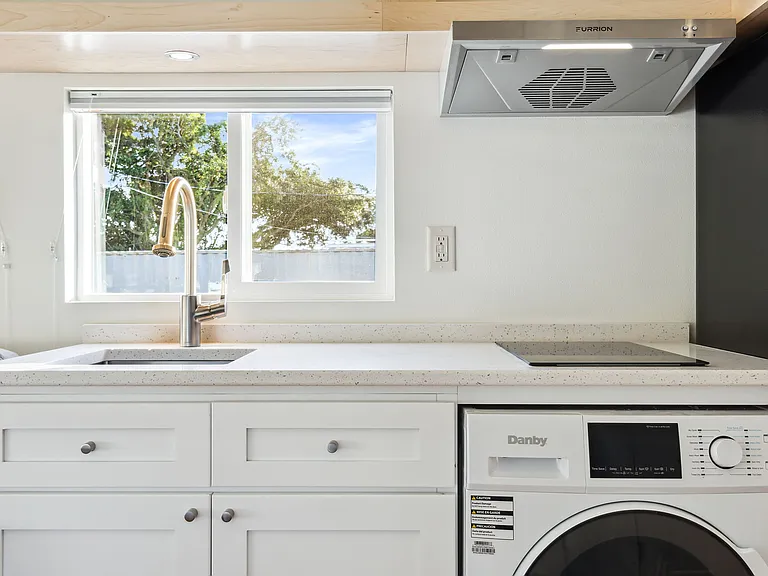 Kitchen with Induction Cooktop and Vent Fan, Tall Fridge over Freezer, and even a convenient Washer/Dryer combo