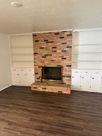 Den with wood burning fireplace. Built in cabinetry with bookshelves