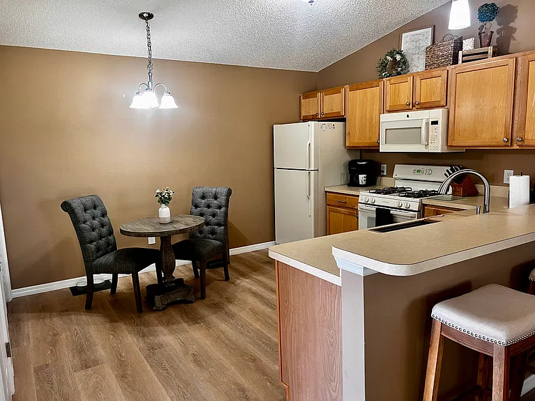 Kitchen with gas cook top, seating for 2, farm sink with raised bar for additional seating.
