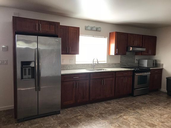 Kitchen includes stainless steel fridge, stove, exhaust hood & microwave