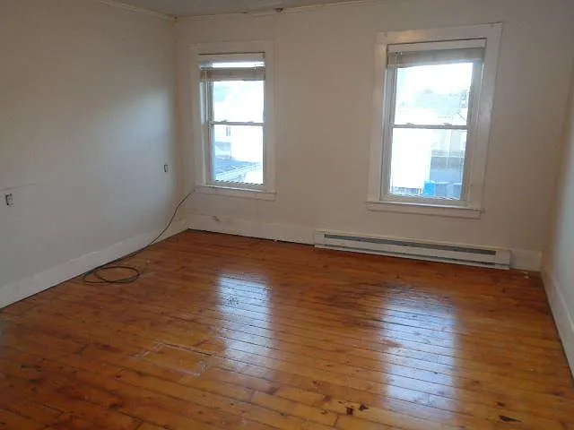 Bedroom 3 View 1. This is medium-sized, as compared to the other two bedrooms. It's interestingly shaped wall is seen in a subsequent photo, and has 2 windows.