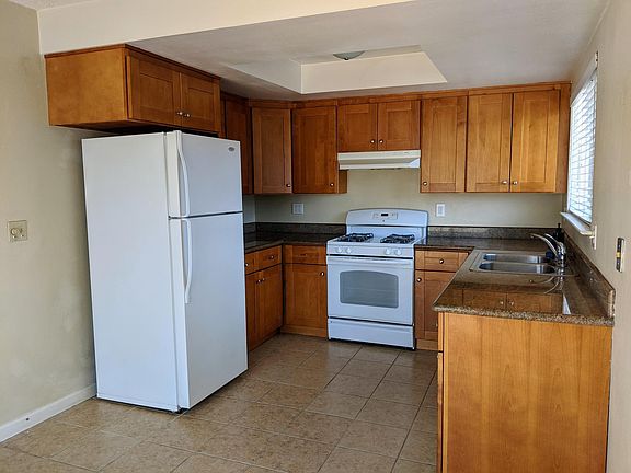 Kitchen, cabinets with granite counters, gas range, double sink, fixed and handheld faucet, garbage disposal, and dishwasher.
