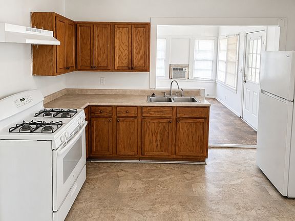 Functional Kitchen featuring cabinet space, gas range, refrigerator, and double sink.