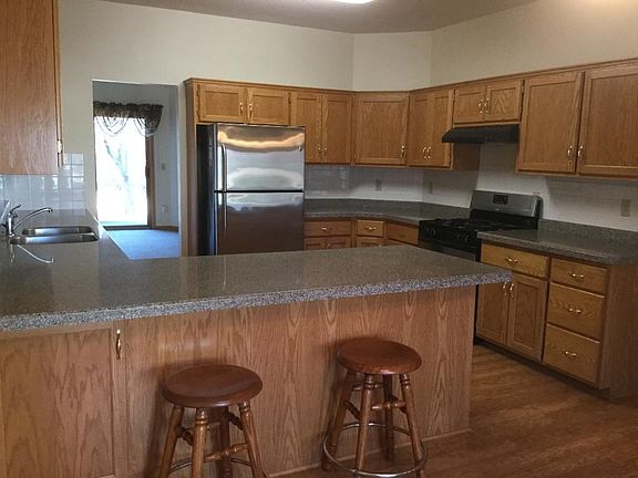 Spacious kitchen with stainless steel appliances, and laminate flooring.