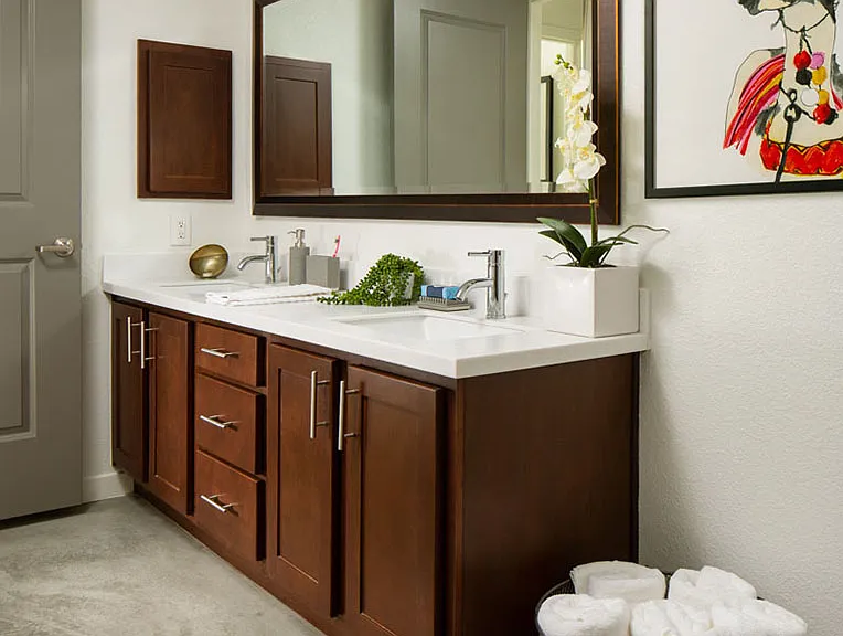 Apartment bathroom with polished concrete flooring and double sinks.