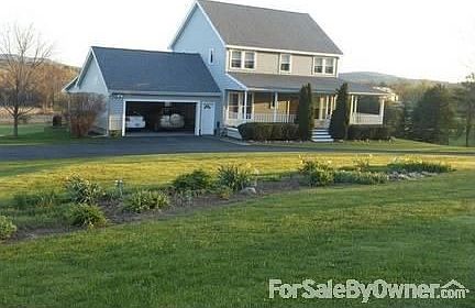 Front view facing SouthWest : Perennial garden on front lawn marks the change of seasons.